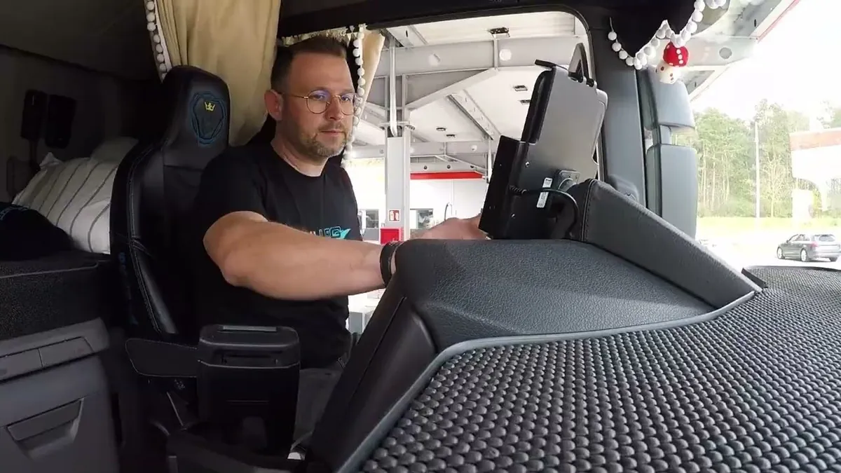 Fahrer bedient PACE Drive auf dem Spedion-Telematik-Tablet im Lkw